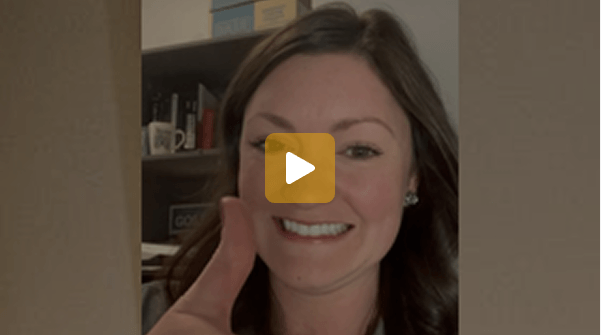 Smiling woman in an office giving a thumbs up in a video thumbnail.