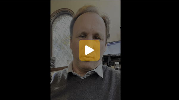 Video thumbnail: man speaking in an office, ready to play (window and computer in background).