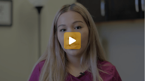 Video thumbnail: young woman with long blonde hair wearing a purple top, speaking indoors with a lavalier mic.